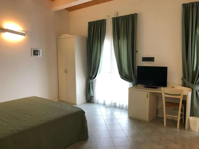 Camera con letto, armadio e porta finestra sul giardino